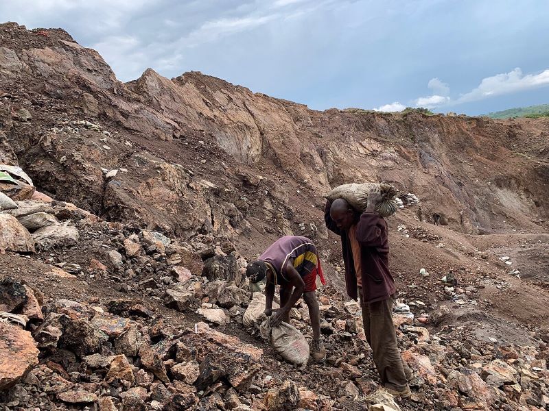 Two men mining in a rocky landscape