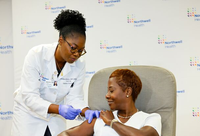 Michelle Chester, FNP-BC, DNP, senior director of Employee Health Services at Northwell Health, administers the 2023-24 Pfizer Covid-19 vaccine to Sandra Lindsay, RN, vice president of public health advocacy at Northwell.