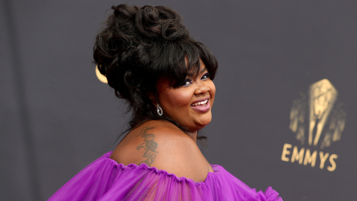 Nicole Byer in off-shoulder dress and updo