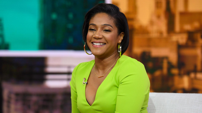 Tiffany Haddish in a short style with hoop statement earrings and a v-cut neon green dress