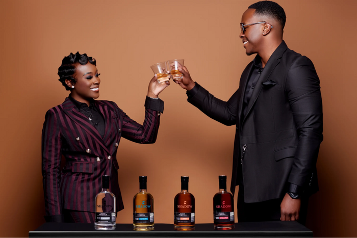 Black man and a black woman, possibly CEO Teddy Jasper and VP Tiara Jasper, toasting with Shadow tequila