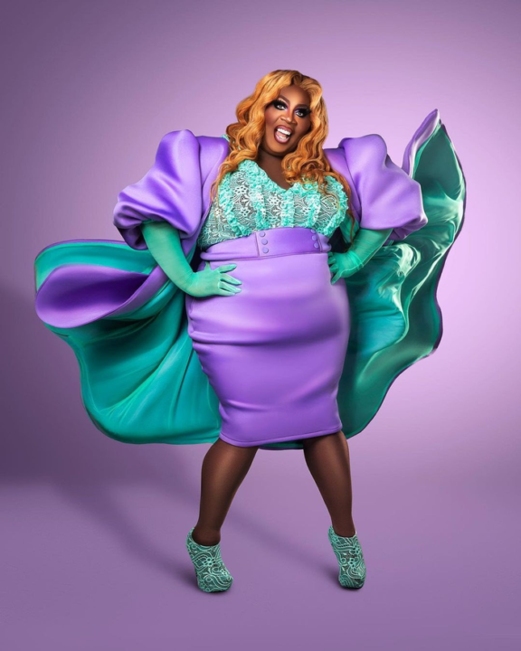 Latrice Royale in a knee-length and puff sleeve dress with purple and green reminiscent of The Little Mermaid