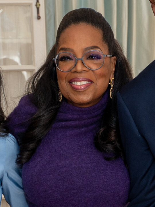 Oprah Winfrey in glasses, turtleneck, and statement earrings