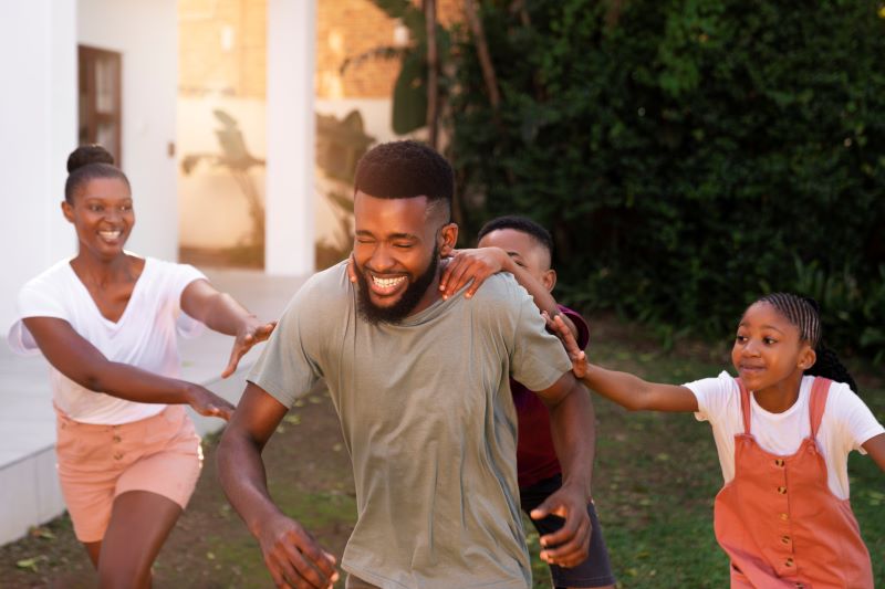 African American man laughing with his family outdoors