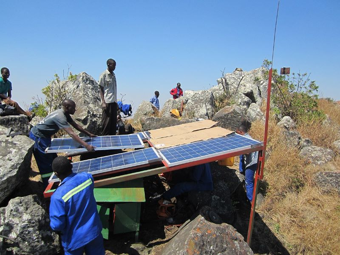 A group of technicians mounting solar panels on a terrain