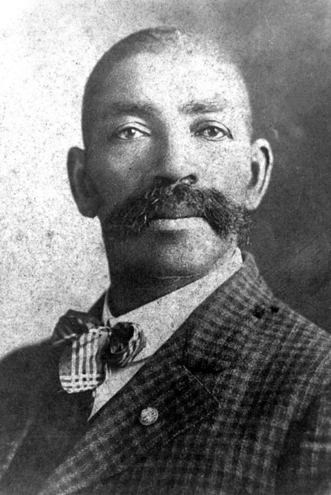 U.S. Marshal Bass Reeves, black and white portrait, he is wearing a tweed suit and sporting a mustache