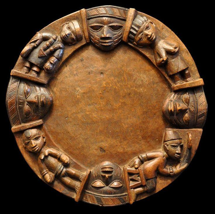 A wooden carved shield depicting Yoruba Orishas, or gods