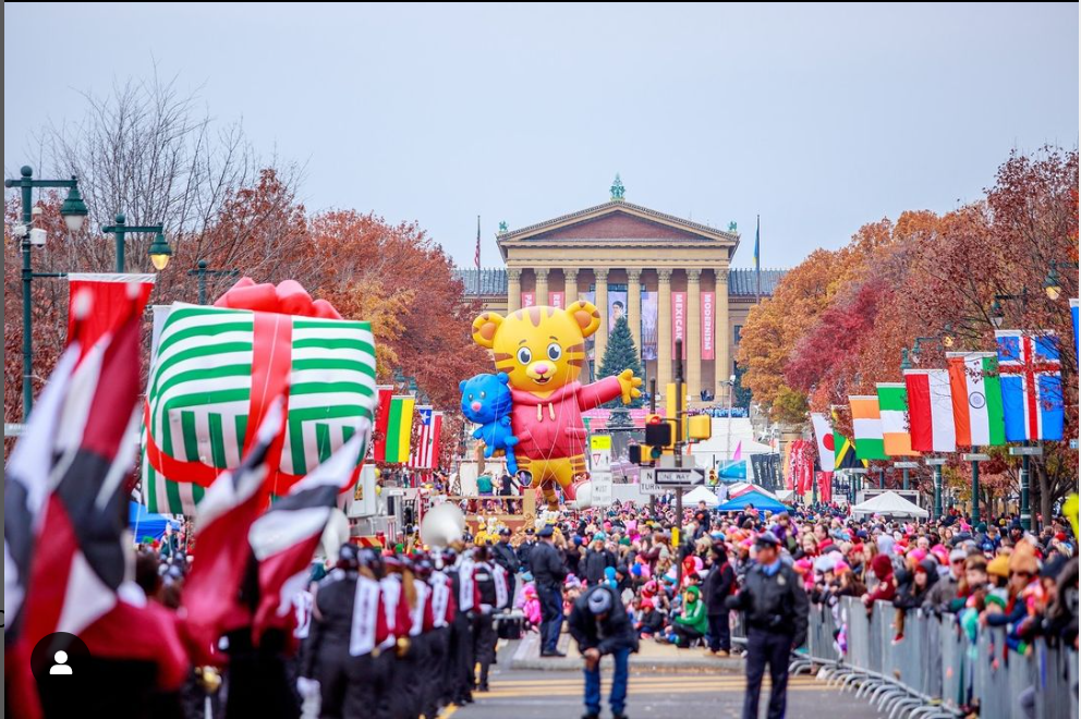 Thanksgiving parade with floats shaped like characters and gifts, in front of the Philadelphia Museum of Art