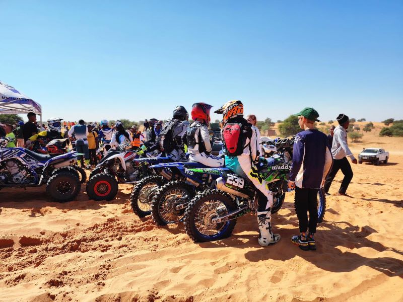 Group of motorcyclists in the desert at the Khawa Dune festival