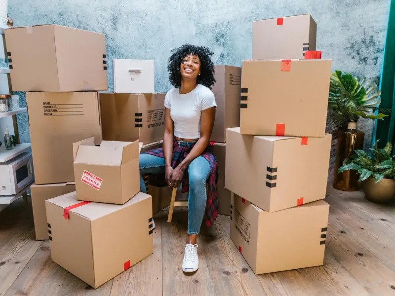 African American woman sitting among moving boxes