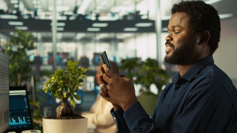an African man checking on his phone for bitcoin movement