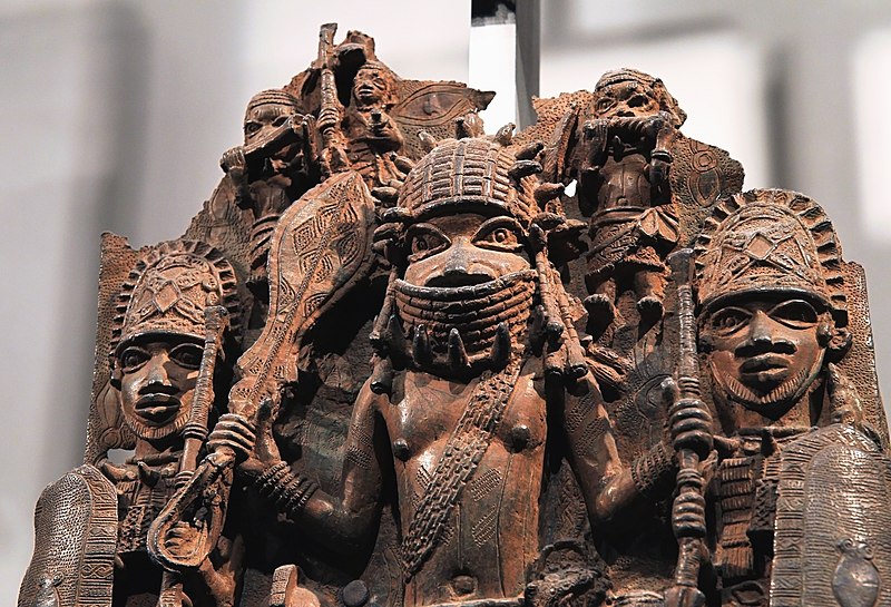 Benin sculpture of warriors in helmets and holding weapons