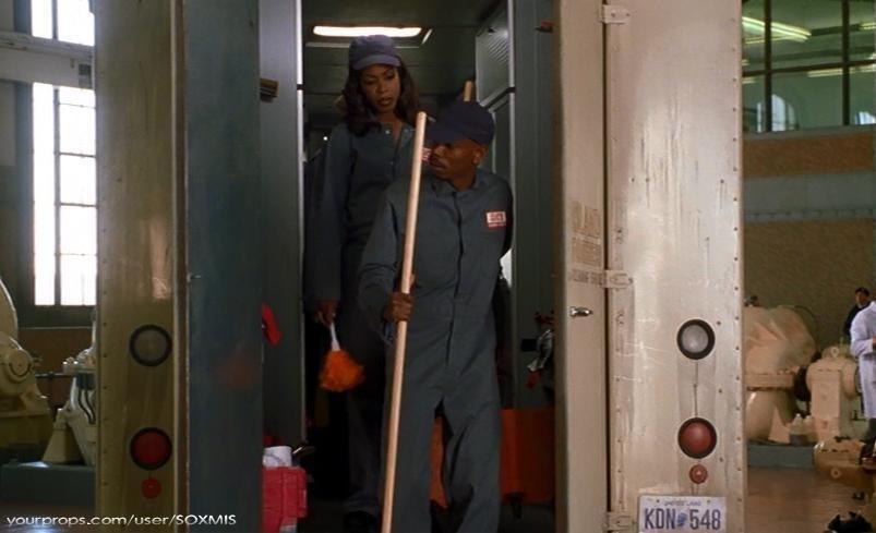 man and woman wearing janitorial jumpsuits and matching cap.