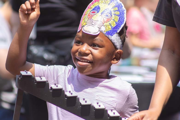 African American boy wearing a handmade paper headband smiling