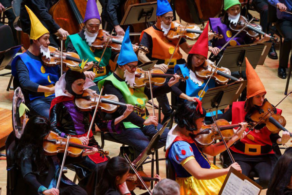 Philadelphia Orchestra string instrumentalists performing while dressed as Snow White and the Seven Dwarves