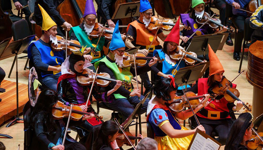 Philadelphia Orchestra string instrumentalists performing while dressed as Snow White and the Seven Dwarves