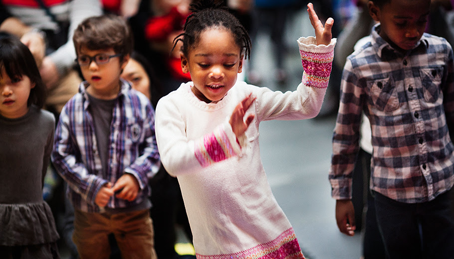 Black girl dancing among group of children