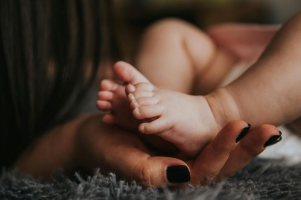 African American baby's feet held in mother's hands