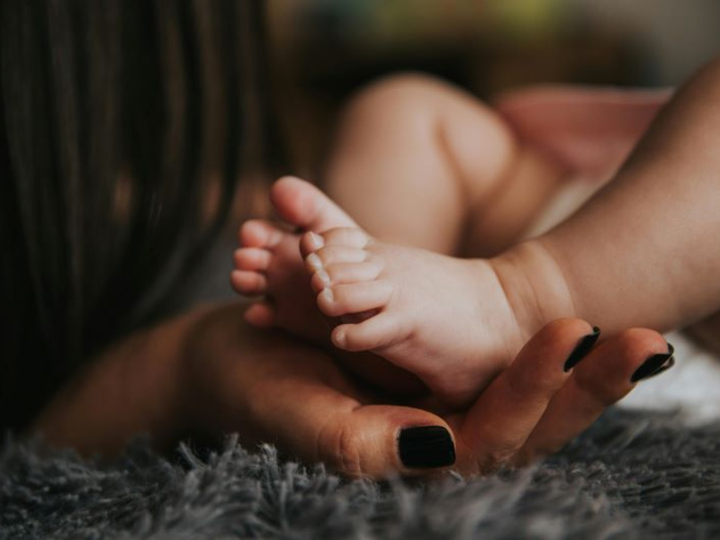 African American baby's feet held in mother's hands