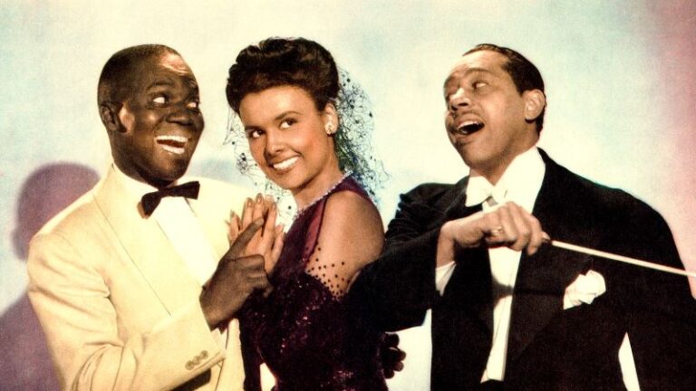 Left to Right: Bill Robinson, Lena Horne, Cab Calloway in the 1943 musical film Stormy Weather. Robinson is in a light colored suit, Horne is wearing a black short veil and halter dress with arm-length gloves, and Calloway is wearing a suit and holding a conductor's baton