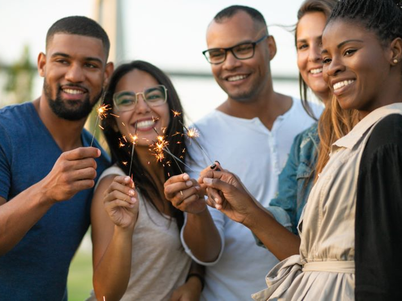 African American and other race friends celebrating with sparklers