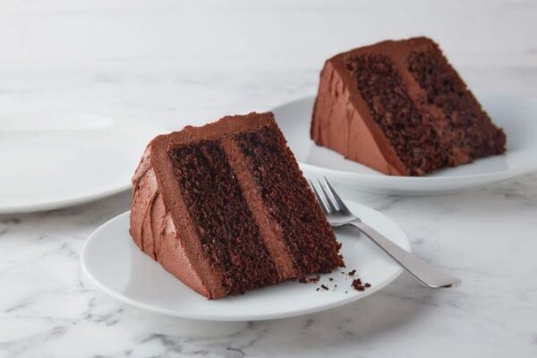 Two slices of chocolate cake on plates