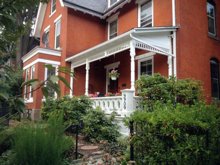 A brick old-fashioned building with a white porch