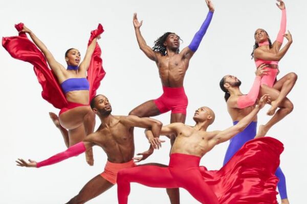 Six dancers in colorful costumes and dynamic poses