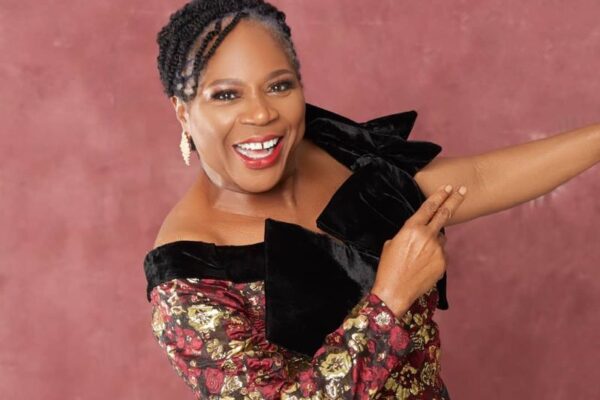 Onyeka Onwenu posing for a photo in an off-shoulder dress