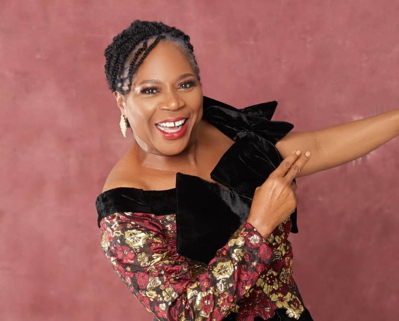 Onyeka Onwenu posing for a photo in an off-shoulder dress