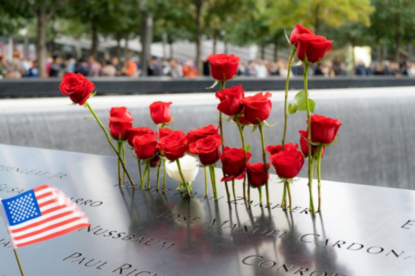 Red carnations and the American flag adorn September 11th memorial