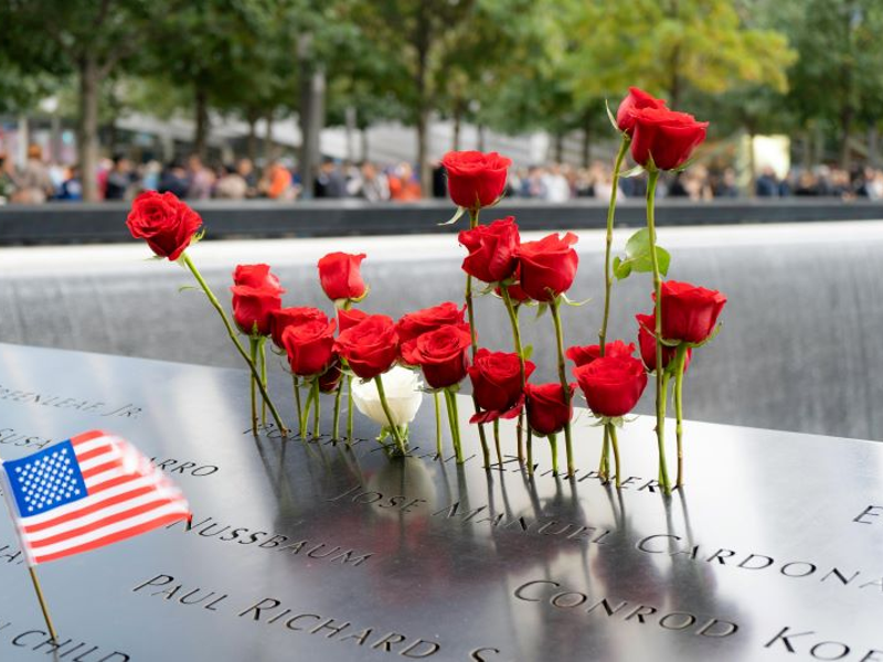 Red carnations and the American flag adorn September 11th memorial