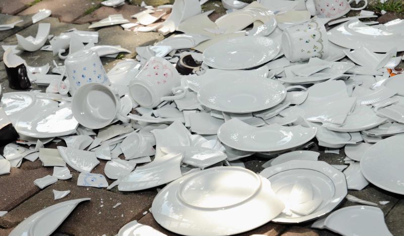 a pile of broken plates and cups on the floor