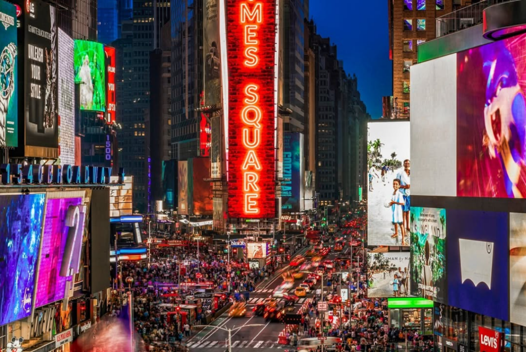 Times Square filled with neon lights and a large crowd