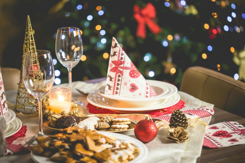 a festive table set up for Christmas, with Christmas tree in the background