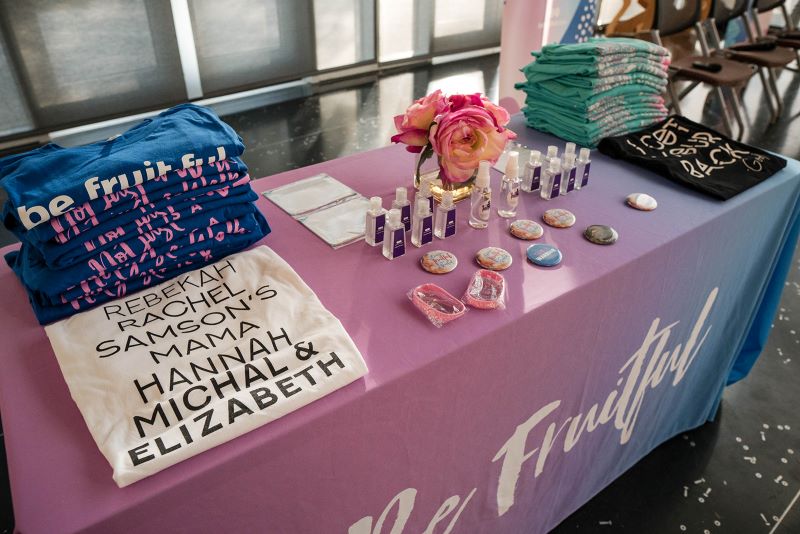 Table of promotional material for Barren Fruit, such as teeshirts,and hand gels.