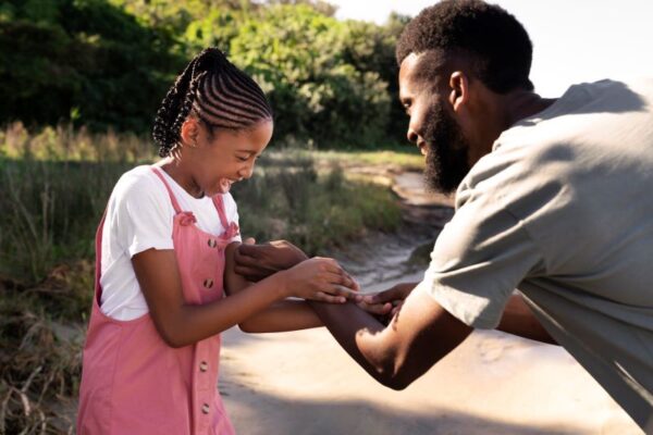 An African American dad spending time with his daughter in nature