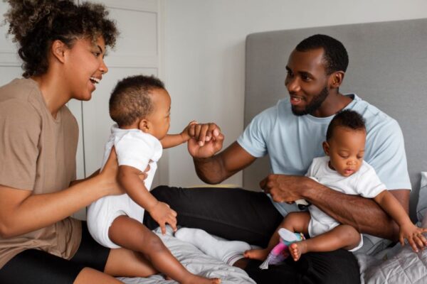 African American parents taking care of two babies, and laughing