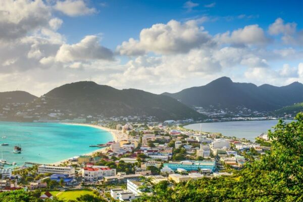 a view of mountains and light blue beaches and the city in St Maarten