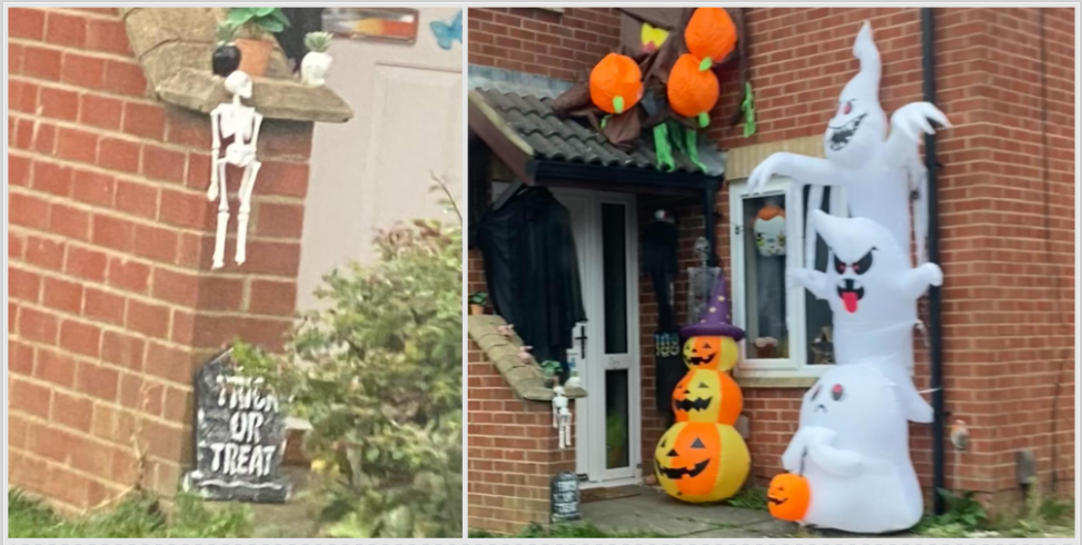 Halloween decorations in front of a house with hanging skeletons, a grave marker, stacked pumpkins, and ghosts