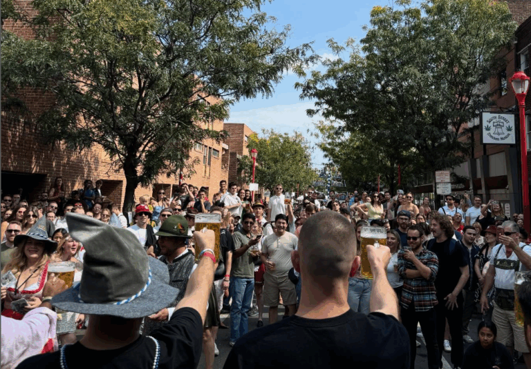a crowd of people toasting and drinking beer outdoors at Philadelphia's Oktoberfest