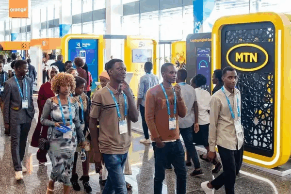 a group of tech professionals at the MWC Kigali walking around booths of various tech companies