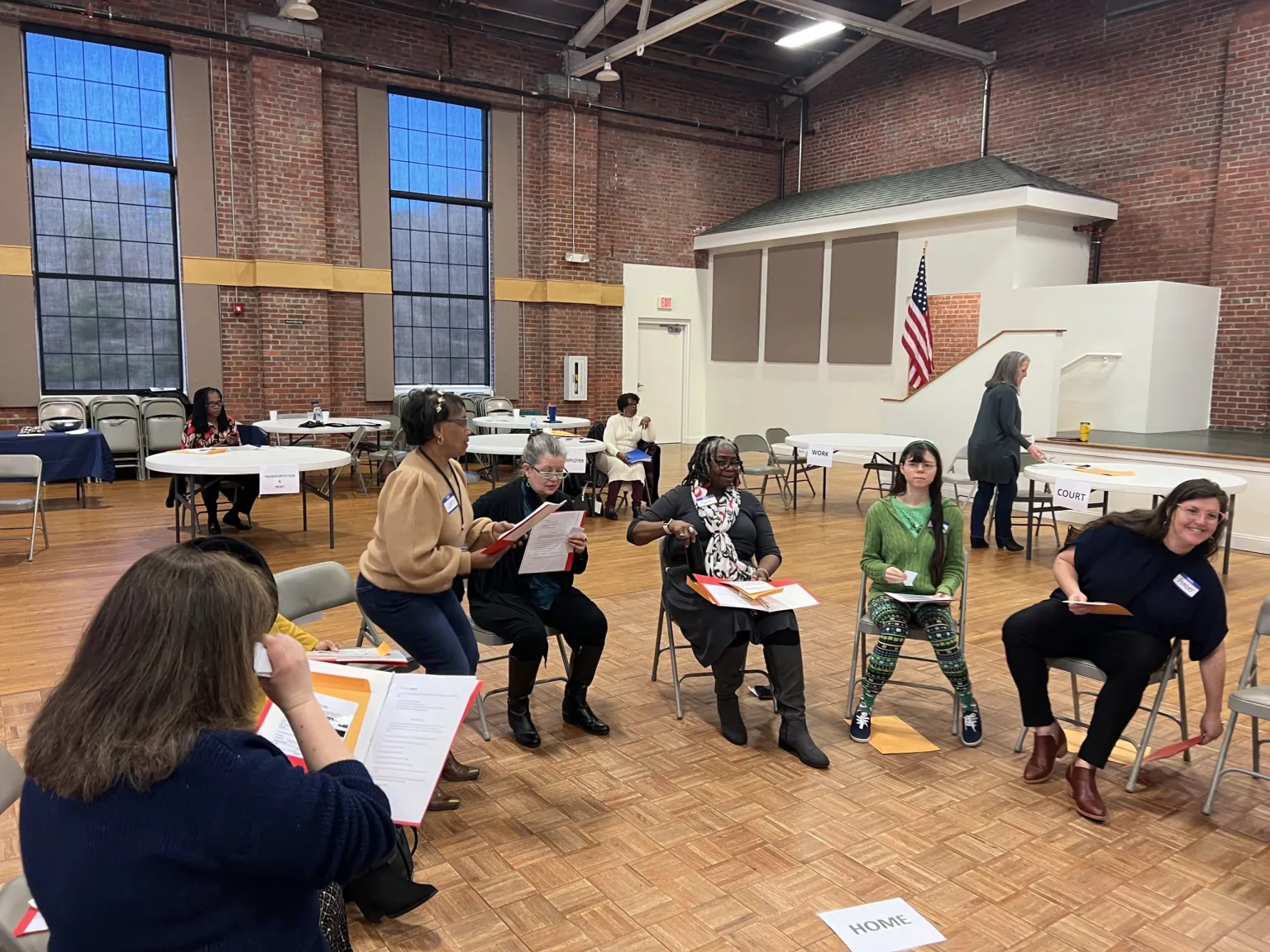 a group of women sitting in a circle, participating in the simulation workshop