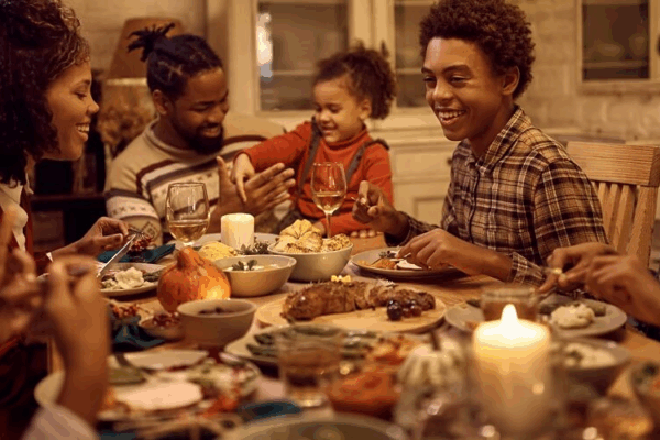 a large African American family gathered around the table for Thanksgiving dinner