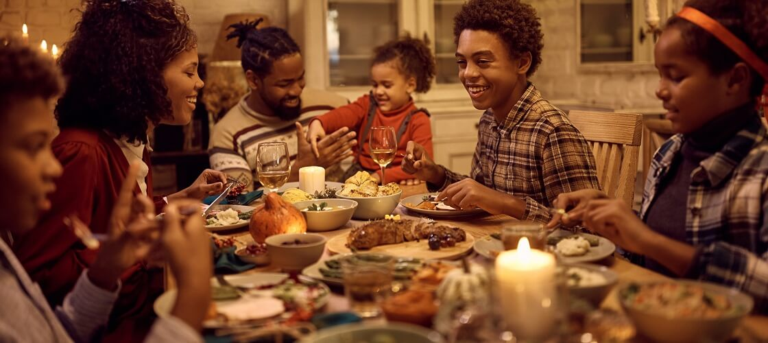 a large African American family gathered around the table for Thanksgiving dinner