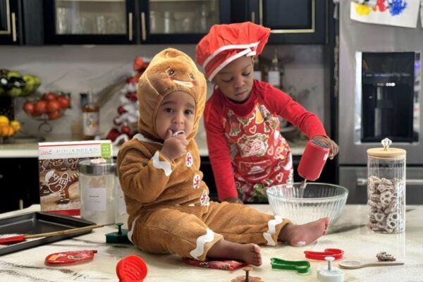 toddlers with holiday cookie cutters helping in the kitchen