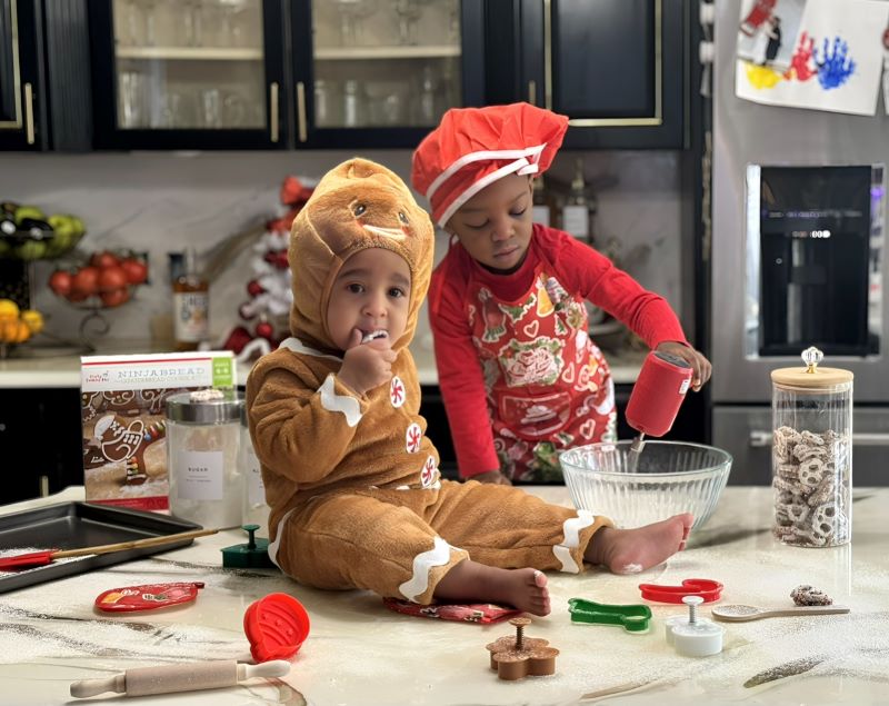 toddlers with holiday cookie cutters helping in the kitchen