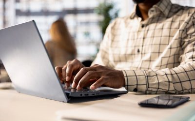 African man typing on laptop in an office