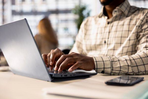 African man typing on laptop in an office