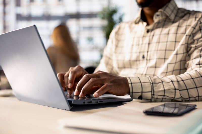 African man typing on laptop in an office